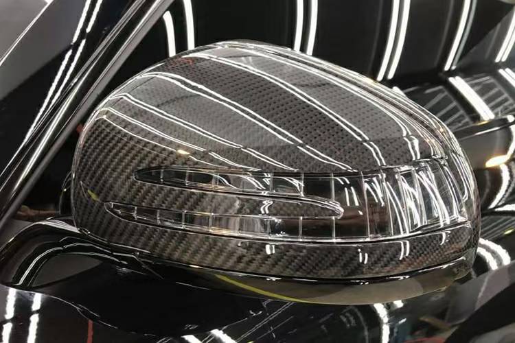 Close-up of gloss carbon weave and indicator opening on a Mercedes-AMG GT C190 mirror cover