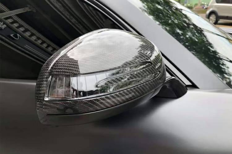 Gloss carbon fibre mirror cover installed on a Mercedes-AMG GT C190, side view with indicator